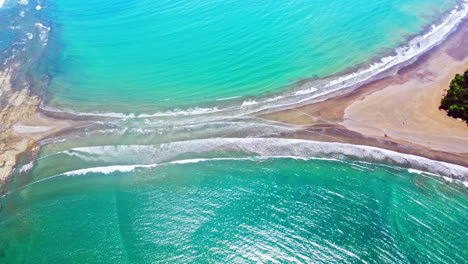 Aerial-drone-footage-revealing-a-beach-shaped-like-a-whale's-tail-in-Ballena-Marine-National-Park,-Costa-Rica