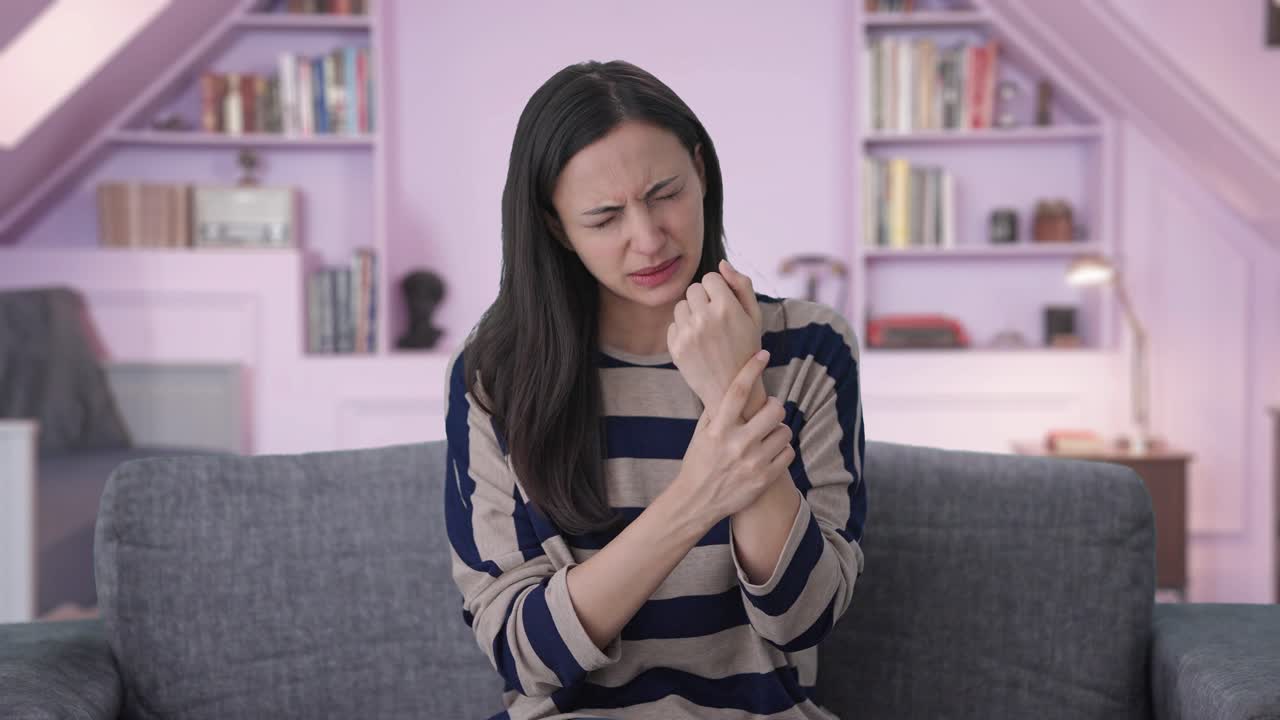 chica india enferma que sufre de dolor en la mano