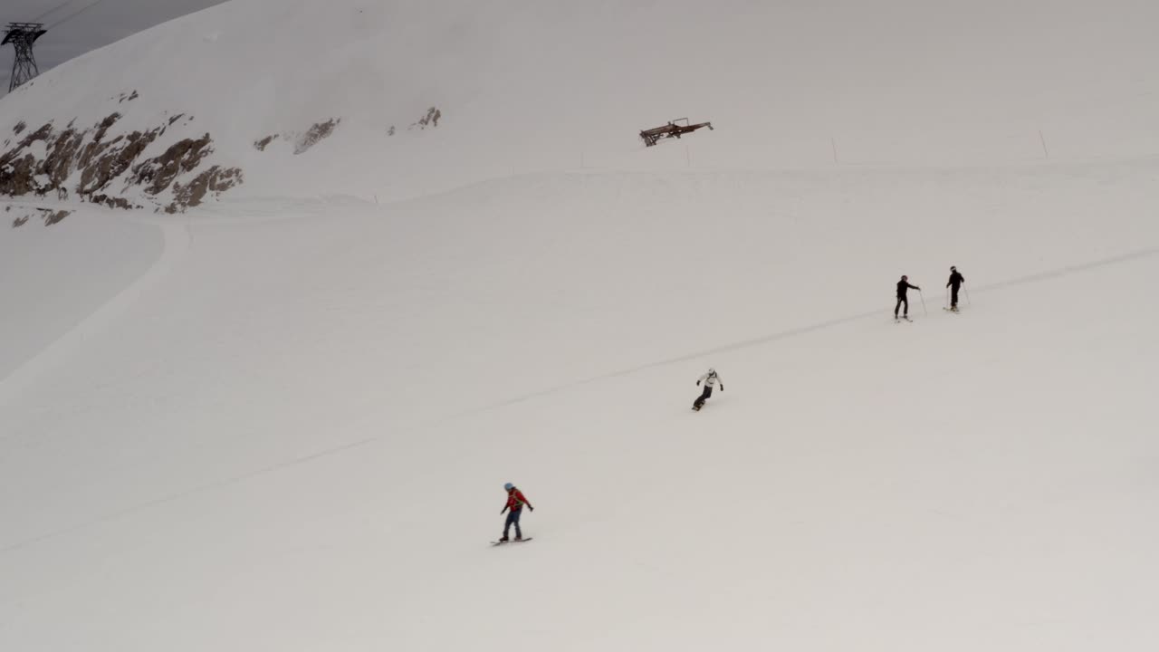 esquiadores y snowboarders en una ladera de montaña nevada