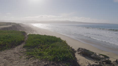 Toma-En-Cámara-Lenta-De-Un-Día-Soleado-En-La-Playa-Estatal-Del-Puerto-Deportivo-De-La-Bahía-De-Monterey-De-California-Con-Gente-Al-Borde-Del-Acantilado