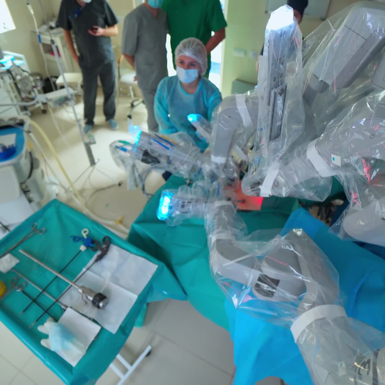 Intelligent machine during minimally invasive surgery. Futuristic robotic equipment doing microsurgery on patient. Medical workers observe robotic surgery. Top view