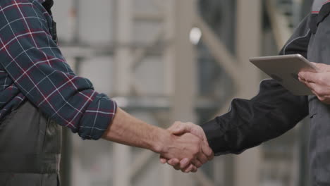 engineers shaking hands at factory