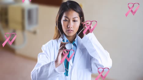 animation of breast cancer awareness ribbons over asian female doctor with stethoscope