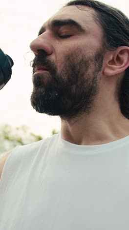 man drinking water during outdoor workout