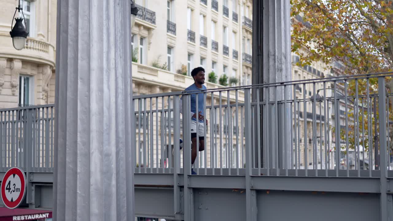 Uomo che corre su un ponte in città