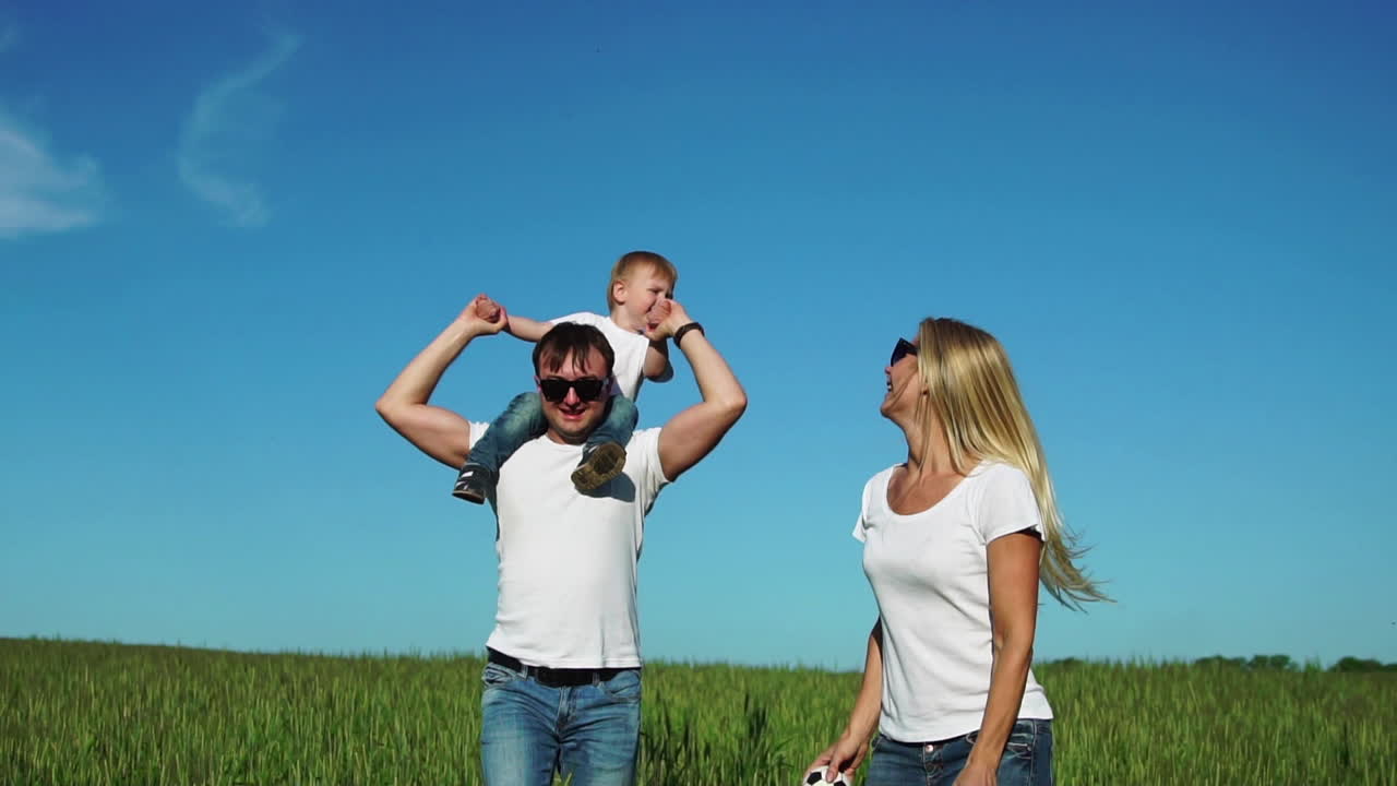 la familia feliz corre y sonríe en el campo con su hijo riendo y tomándose de las manos. hijo sentado en el látigo
