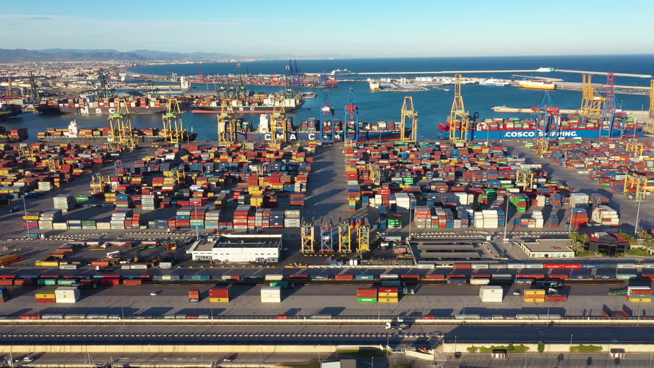 Left to right aerial traveling over Port of Valencia trucks, containers Spain