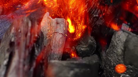 burning charcoal, glowing embers with crackling heat and fiery sparks flying