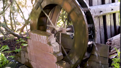 small garden watermill wheel turning in a small stream by wooden fence