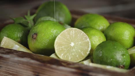 on limes in a wooden box falling water drops.