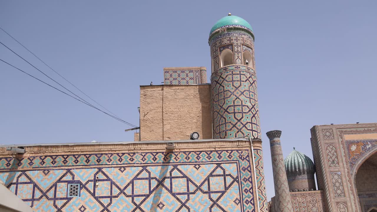 alto minarete con cúpula azul brillante en la plaza registan en samarcanda, uzbekistán a lo largo de la histórica ruta de la seda