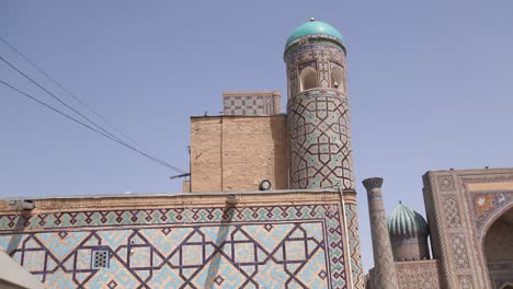 tall minaret with bright blue dome in registan square in samarkand, uzbekistan along the historic silk road