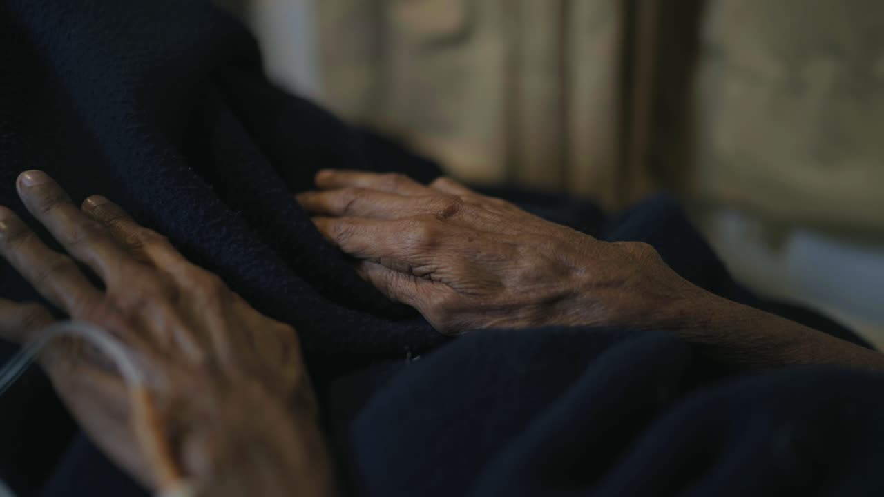 Elderly male hands with an IV catheter.