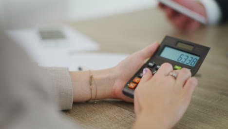 close-up of woman's hands using calculator