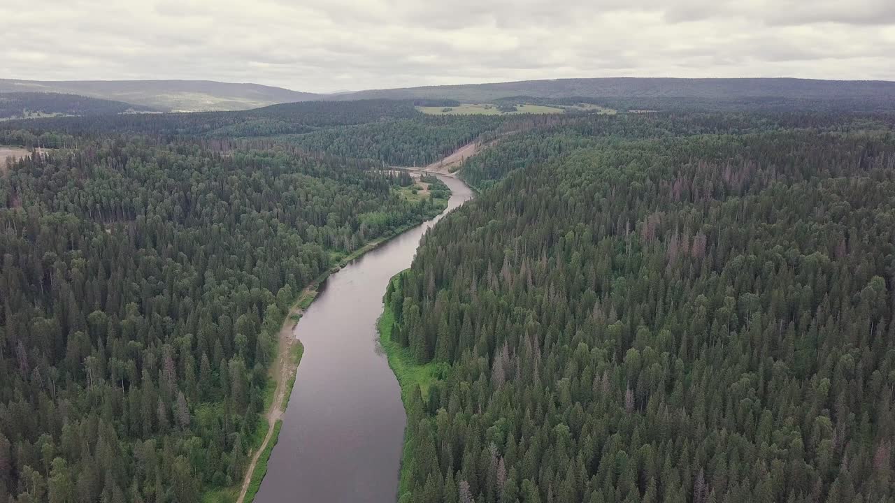 Ilmakuva mutkittelevasta joesta tiheän metsän läpi
