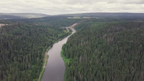 aerial view of a winding river through a dense forest