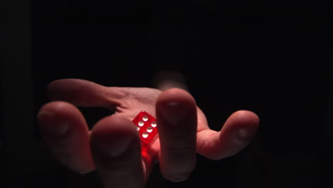 hand grasping red dice