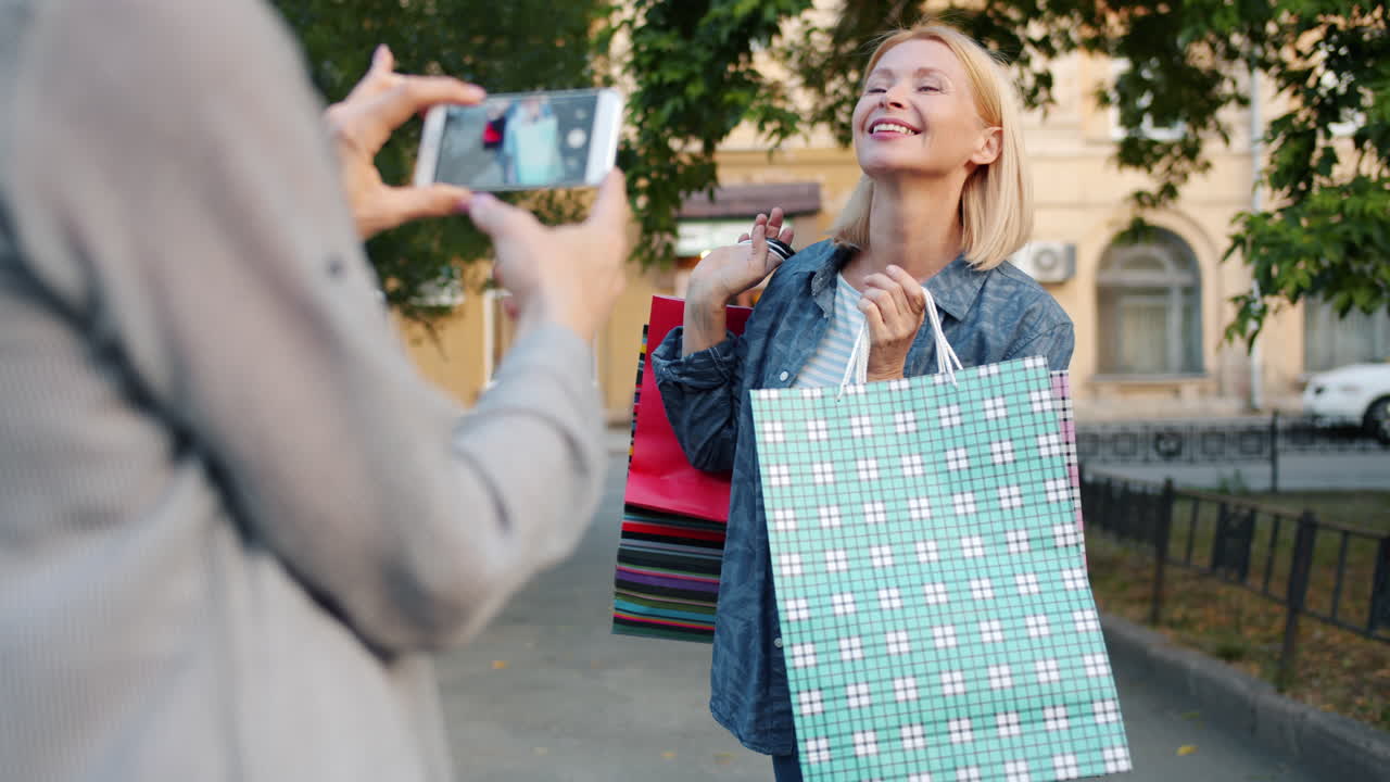 Woman Taking Photo of Friend with Shopping Bags