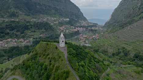 vista a vista de pájaro sobre la iglesia de la torre en madeira, portugal, con vistas al valle y al mar