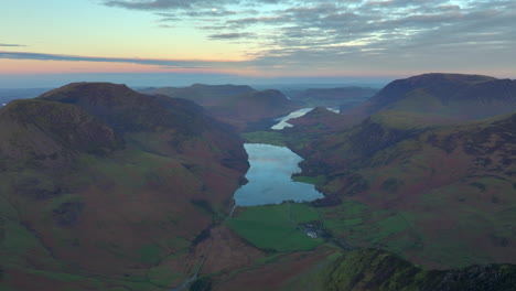 Valle-Oscuro-Antes-Del-Amanecer-Con-Un-Lago-Rodeado-De-Montañas