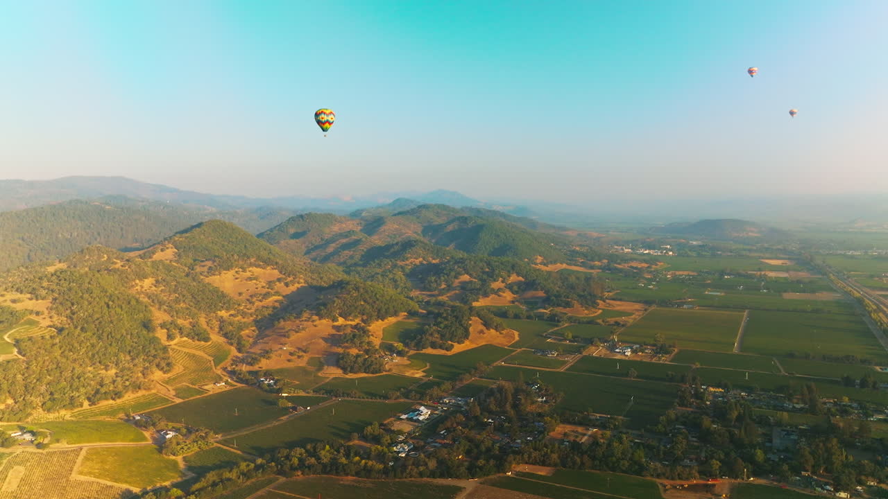 Hot air balloons soaring over the rock formations in Napa, California, USA. Sunny scenery at the backdrop of blue skies.
