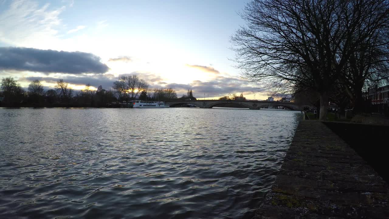 테임즈 강을 가로질러 해가 지는 모습과 멀리 있는 케이브 다리