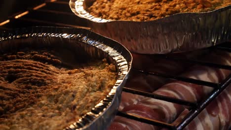 Prepared-stuffing-and-bacon-wrapped-sausage-cooking-on-oven-shelf-rack-dolly-right-close-up