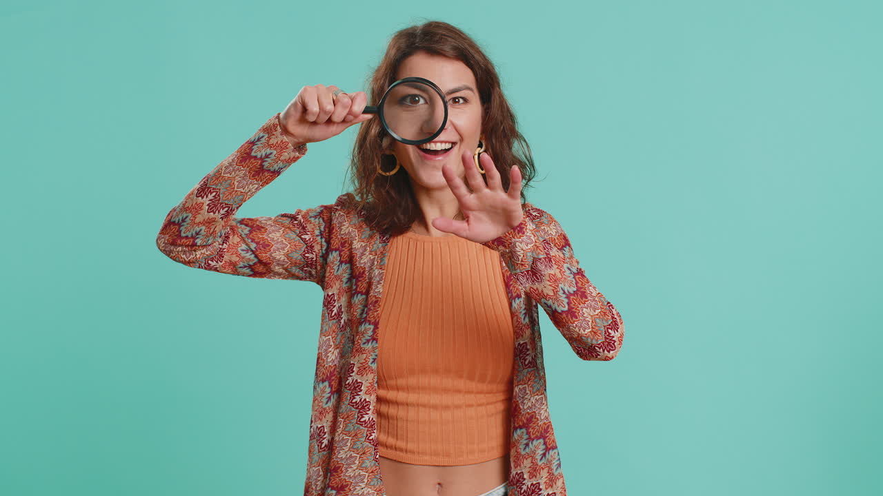 Investigator researcher woman with magnifying glass near face looking into camera with big zoom eye