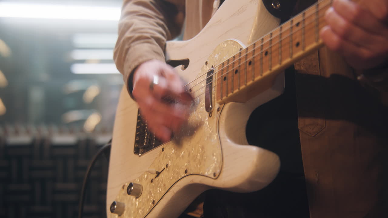 primer plano de una persona tocando una guitarra eléctrica