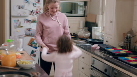 una adolescente feliz bailando con su hermana pequeña en la cocina hermanos divirtiéndose disfrutando de un baile divertido en casa juntos el fin de semana
