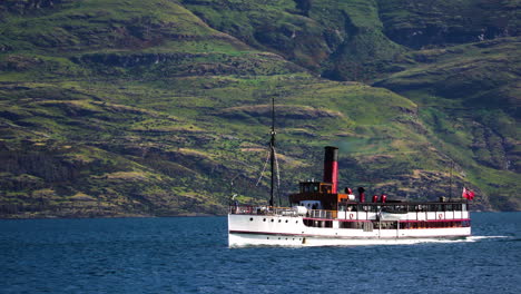 TSS-Earnslaw-vessel-sailing-near-New-Zealand-landscape,-follow-view