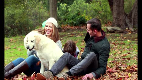 familia con su perro en el día de otoño en el parque