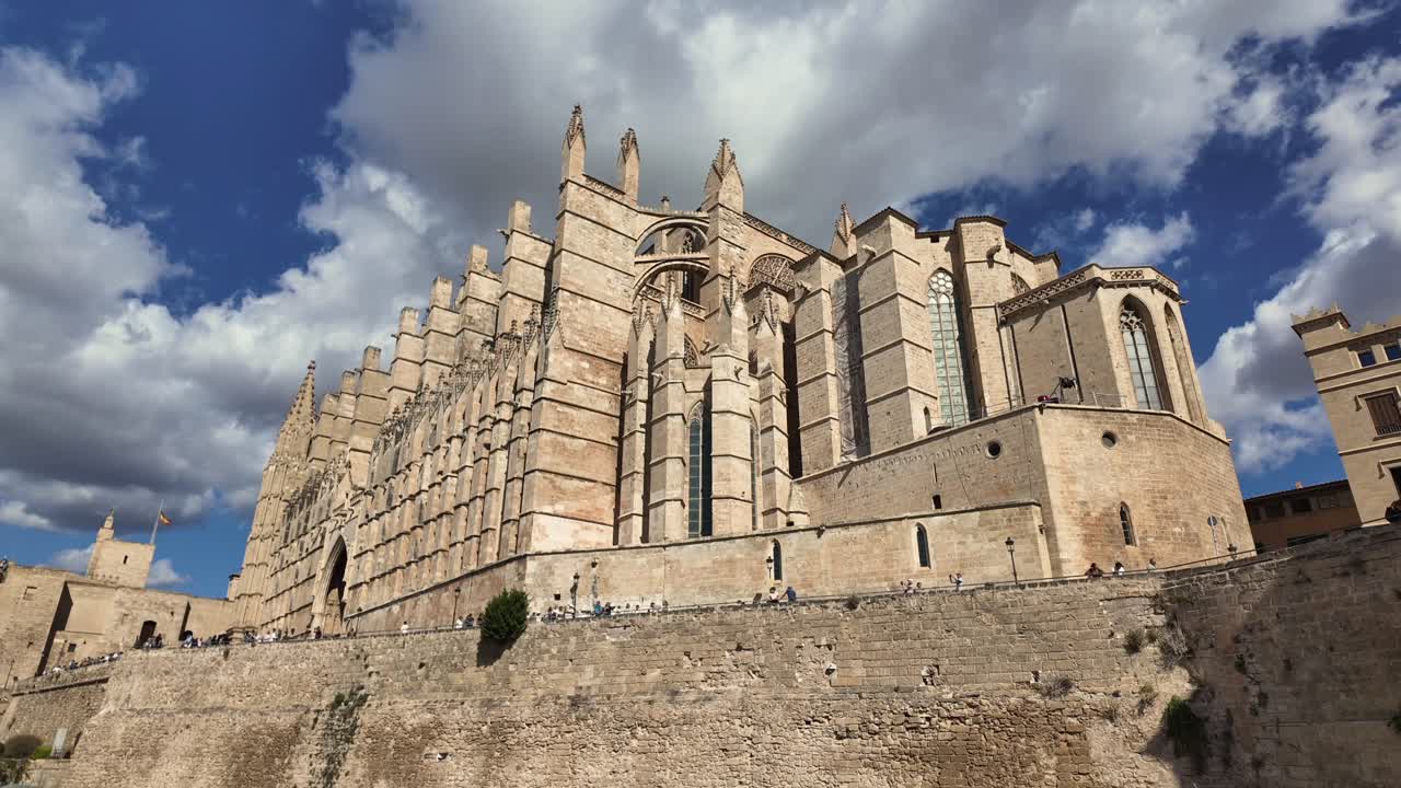 Palma de Mallorca’s cathedral. Time lapse of the monument, low angle view, under a blue sky in a summer day with some clouds. 4K