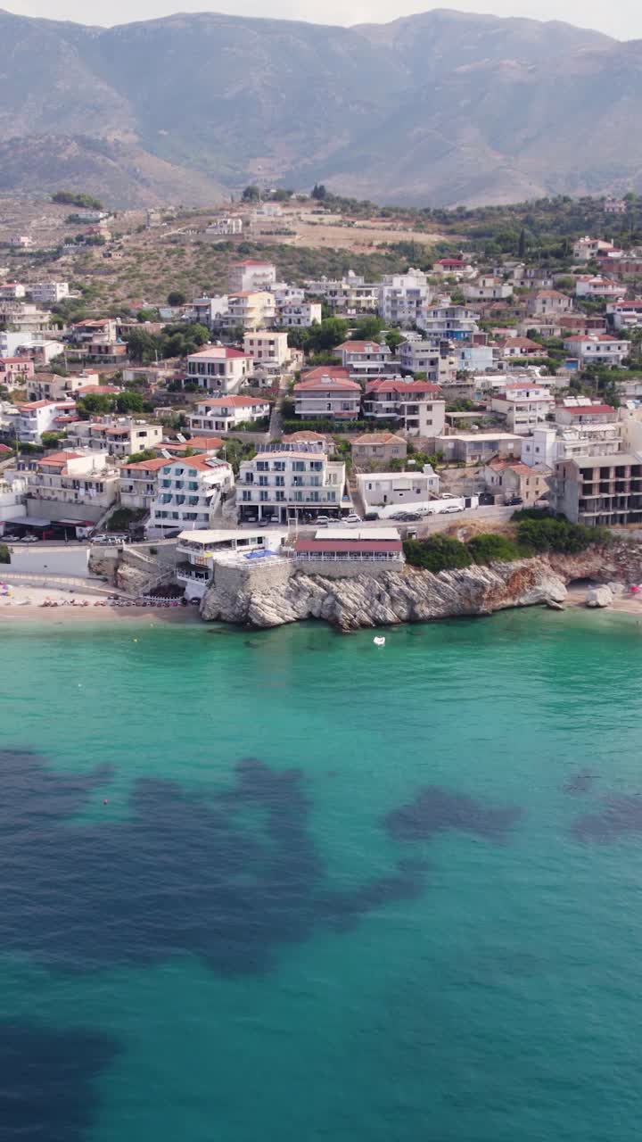 Cliffside homes and clear sea in Himarë Albania vertical