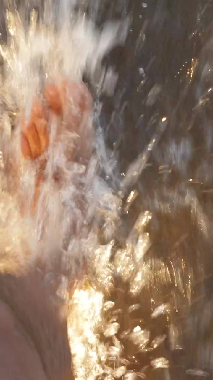 Uomo a piedi nudi che corre sulla spiaggia, il mare che gli bagna i piedi