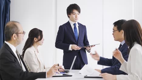 asian businessman explaining at a meeting