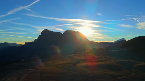 Berge,-Wald-Und-Grasfelder-Mit-Holzhütten,-Gefilmt-Auf-Der-Seiser-Alm-In-Den-Alpen,-Italienische-Dolomiten,-Gefilmt-In-Leuchtenden-Farben-Bei-Sonnenaufgang