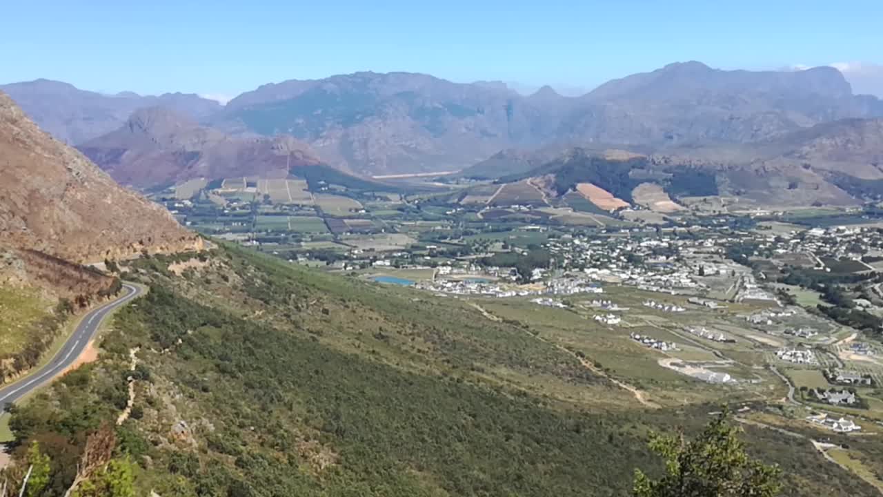una panorámica lenta a través del paso de montaña de franschhoek con la ciudad de franschhoek visible debajo