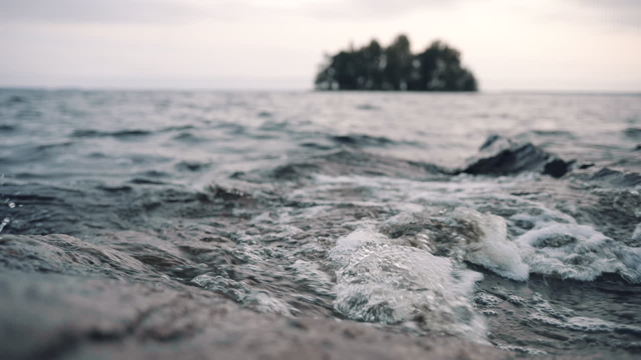 핀란드의 흐린 가을날, 섬 앞의 바위 해안을 치는 파도에 근접