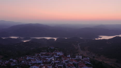 Wunderschöne-Drohnenaufnahme-Aus-Der-Luft-über-Einer-Spanischen-Stadt-Während-Der-Morgendämmerung,-Die-Die-Ganze-Stadt-Und-Ihre-Wunderschöne-Fluss--Und-Berglandschaft-Zeigt,-Zufre,-Spanien