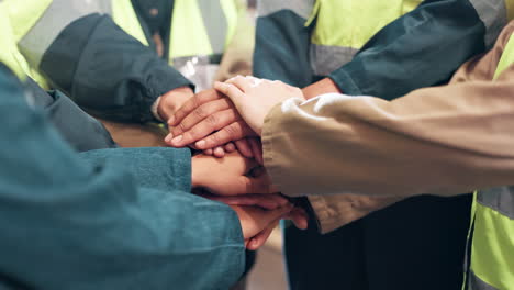 a group of people stacking their hands in a sign of unity and collaboration