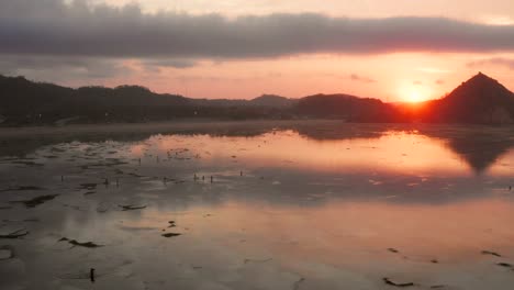 the dry reef of kuta lombok during sunrise, with local people looking for food and seashells