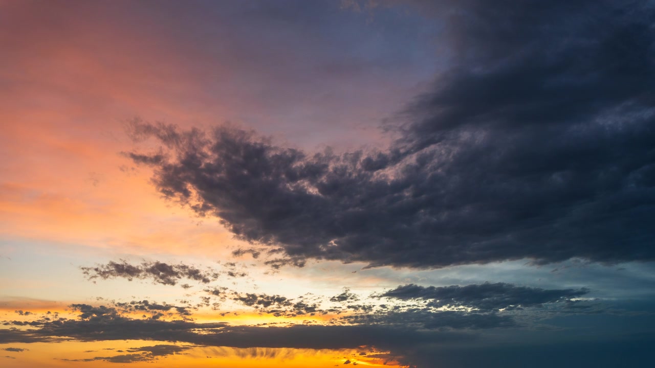 Golden sunset cloud formations shifting across a vivid evening sky
