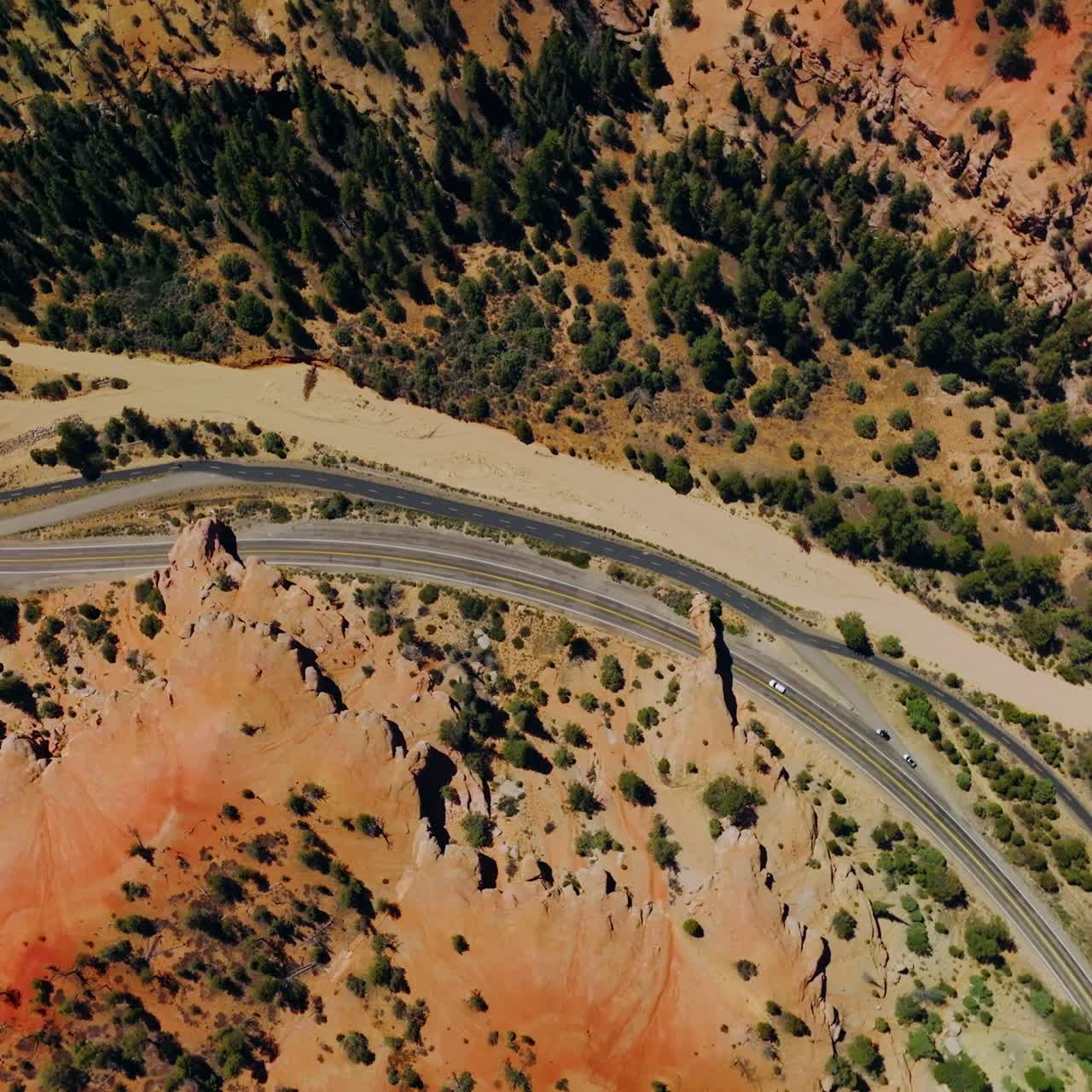 Highways in the mountains. Rocky landscape with sparse pine trees. Sunny scenery of Arches canyons from top view