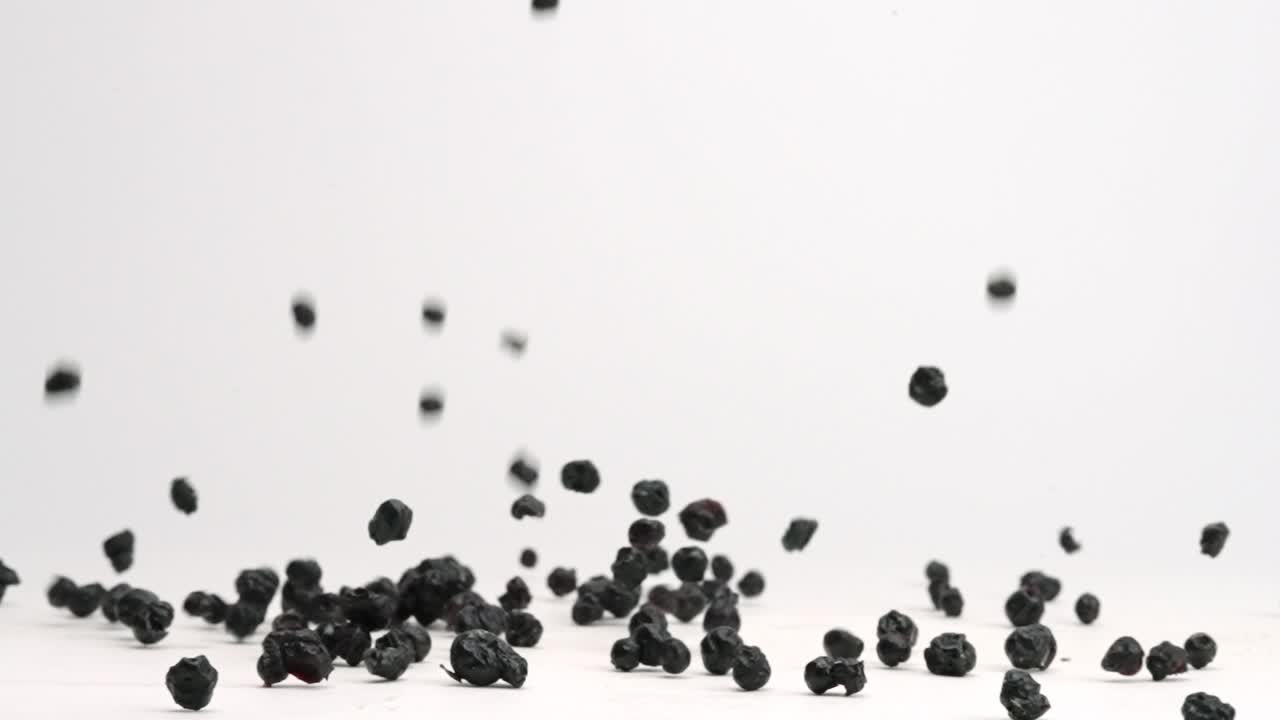 느린 동작으로 흰색 테이블 위에 튀는 동결건조 블루베리