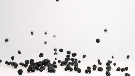 freeze dried blueberries bouncing onto white table top in slow motion