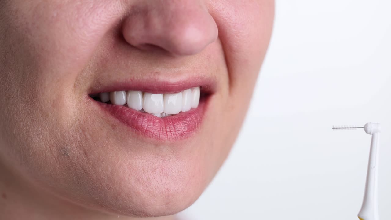 Woman using interdental brush for oral hygiene