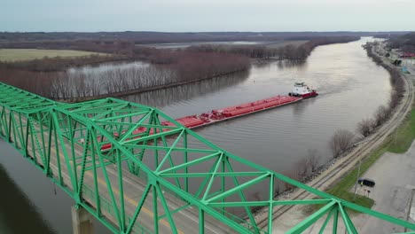 aerial view of barge going under empty bridge