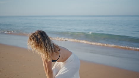 sensual woman artist dancing moving slim body on sunny sand beach close up.