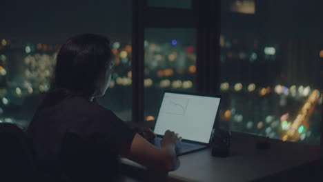 european woman typing text at night with graphics on the screen